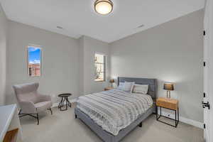 Bedroom with carpet, baseboards, and multiple windows