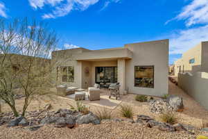Back of property featuring stucco siding, an outdoor living space, and a patio