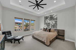 Carpeted bedroom featuring recessed lighting, a tray ceiling, and baseboards