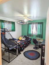 Carpeted bedroom featuring ceiling fan