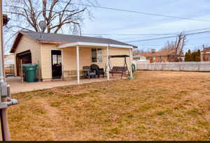 Different angle of backyard with detached garage & covered patio