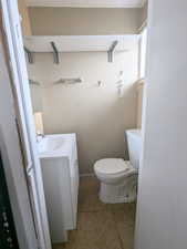 1/2 Bathroom with vanity, tile patterned floors, and toilet located in upstairs bedroom