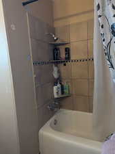 Bathroom featuring shower / bathtub combination with curtain