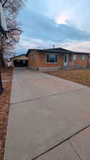 View of front of property featuring long driveway & detached garage