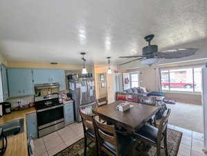 Open floor Kitchen view with family room, ceiling fan, stainless steel appliances,