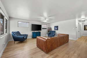 Living room with ceiling fan and light wood-type flooring