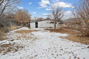 Snowy yard with an outbuilding