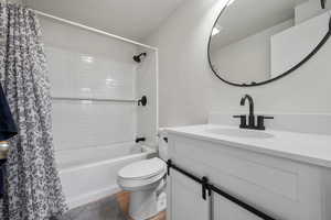 Full bathroom featuring vanity, wood-type flooring, shower / tub combo with curtain, and toilet