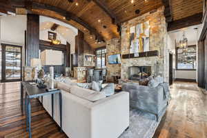 Living room with wood ceiling, a healthy amount of sunlight, dark hardwood / wood-style floors, and high vaulted ceiling