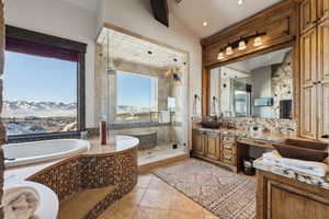 Bathroom featuring lofted ceiling, a mountain view, vanity, and plus walk in shower