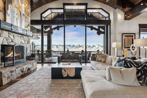 Living room featuring wood-type flooring, high vaulted ceiling, wooden ceiling, a mountain view, and a fireplace