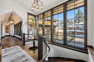 Interior space with dark wood-type flooring, vaulted ceiling, and a notable chandelier