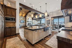 Kitchen featuring pendant lighting, sink, black microwave, and a spacious island