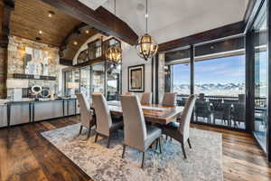 Dining area with vaulted ceiling with beams, hardwood / wood-style floors, wooden ceiling, and a chandelier