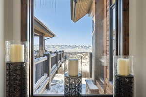 Snow covered back of property with a mountain view