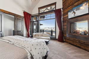 Bedroom featuring high vaulted ceiling, carpet, a water and mountain view, and access to outside