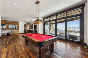 Rec room with a mountain view, dark hardwood / wood-style floors, pool table, and wood walls