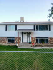 View of front of house featuring central AC and a front lawn