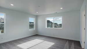 Carpeted empty room featuring recessed lighting, visible vents, and baseboards