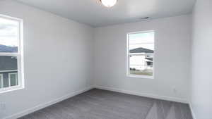 Carpeted empty room featuring visible vents and baseboards