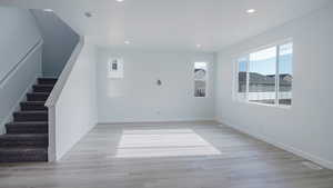 Unfurnished room featuring light wood-type flooring, visible vents, baseboards, and recessed lighting