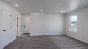 Empty room with visible vents, baseboards, dark colored carpet, and recessed lighting