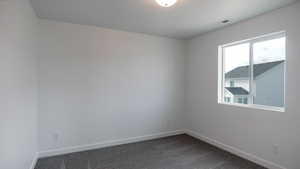 Unfurnished room with carpet, visible vents, and baseboards