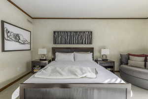 Carpeted bedroom with crown molding