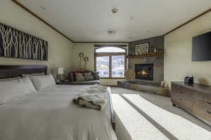 Bedroom featuring a fireplace, ornamental molding, and carpet flooring