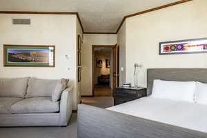 Carpeted bedroom with ornamental molding