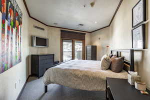 Bedroom featuring ornamental molding and carpet