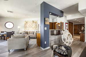 Living room with light hardwood / wood-style floors and a textured ceiling