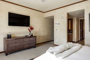 Carpeted bedroom with ornamental molding