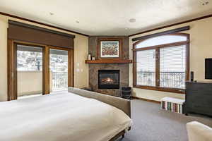 Bedroom with a fireplace, crown molding, access to outside, and carpet flooring