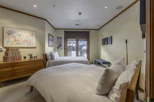 Carpeted bedroom with crown molding