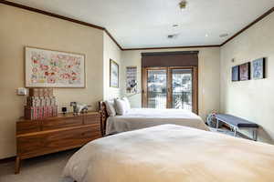 Bedroom featuring crown molding, carpet floors, and access to outside