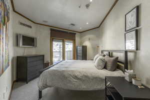 Carpeted bedroom with ornamental molding