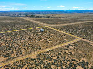 Aerial view of sparsely populated area featuring property parcel outlined and a mountainous background