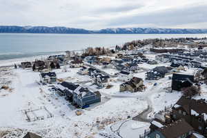 Snowy aerial view featuring a water and mountain view