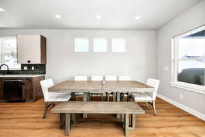 Dining area with sink and light wood-type flooring