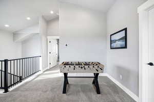 Game room featuring vaulted ceiling and carpet