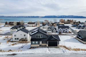 Snowy aerial view featuring a water and mountain view