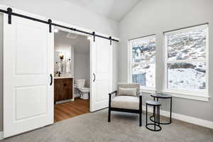 Sitting room featuring lofted ceiling and a barn door