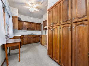 Kitchen with sink, a textured ceiling, and ceiling fan