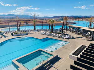 View of pool featuring a community hot tub, a water and mountain view, and a patio