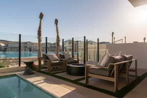 View of patio featuring a community pool and an outdoor fire pit