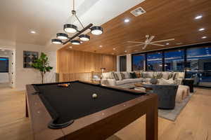 Recreation room with a notable chandelier, wood ceiling, pool table, and light wood-type flooring