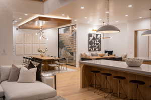 Kitchen with a notable chandelier, a kitchen bar, hanging light fixtures, and light hardwood / wood-style flooring