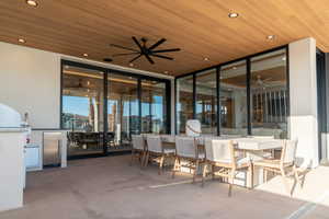 View of patio with ceiling fan and an outdoor bar