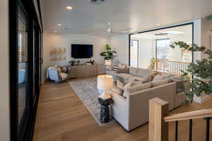 Living room featuring hardwood / wood-style flooring and ceiling fan